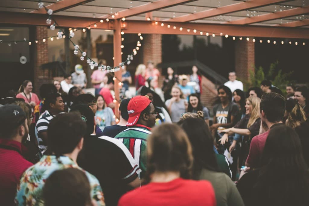 Guests celebrating at an outdoor event with string lights